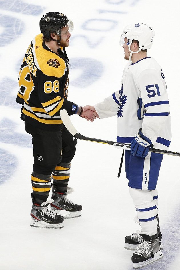Hokejový útočník Bostonu David Pastrňák (88) si třese rukou s obráncem Toronta Jakem Gardinerem (51) po rozhodující bitvě 1. kola play off. Postup slaví Bruins.