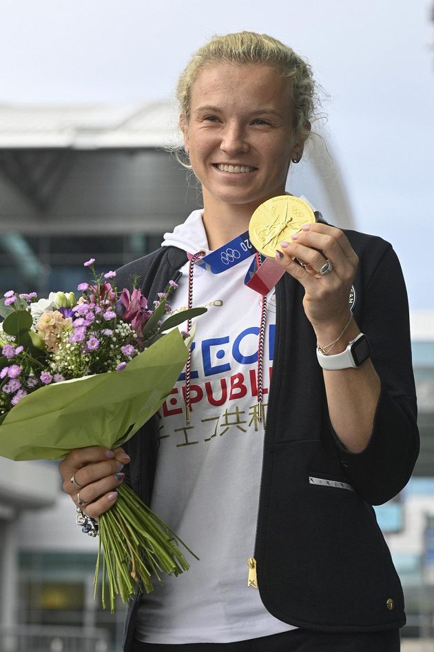 Tenistka Kateřina Siniaková pózuje se zlatou medaili z ženské čtyřhry po příletu z olympijských her v Tokiu.