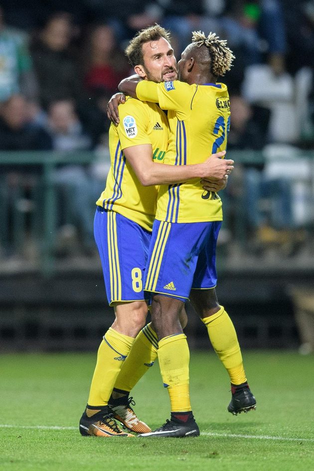 Fotbalisté Zlína Petr Jiráček (vlevo) a Mosses Ekpai oslavují vedoucí gól na Bohemians.