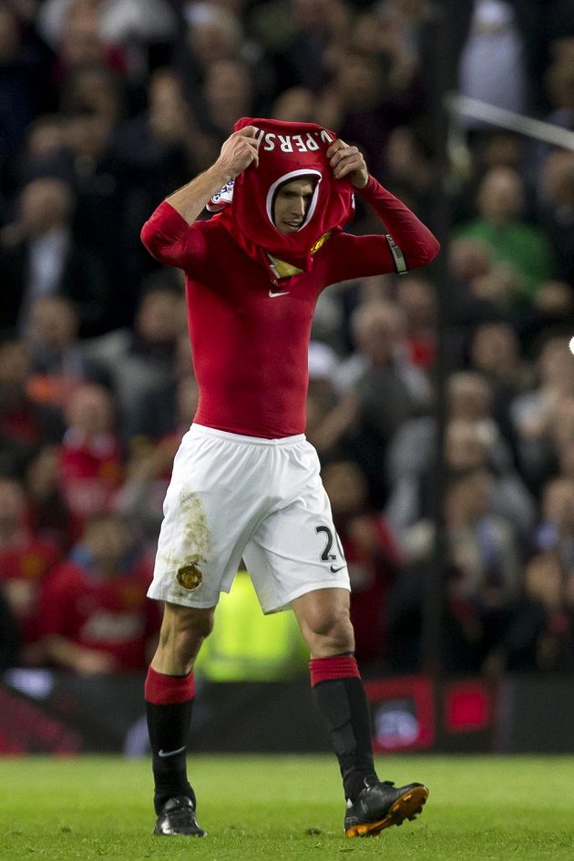 Útočník Manchesteru United Robin van Persie se navléká dres po oslavě své vyrovnávací branky v duelu s Chelsea.
