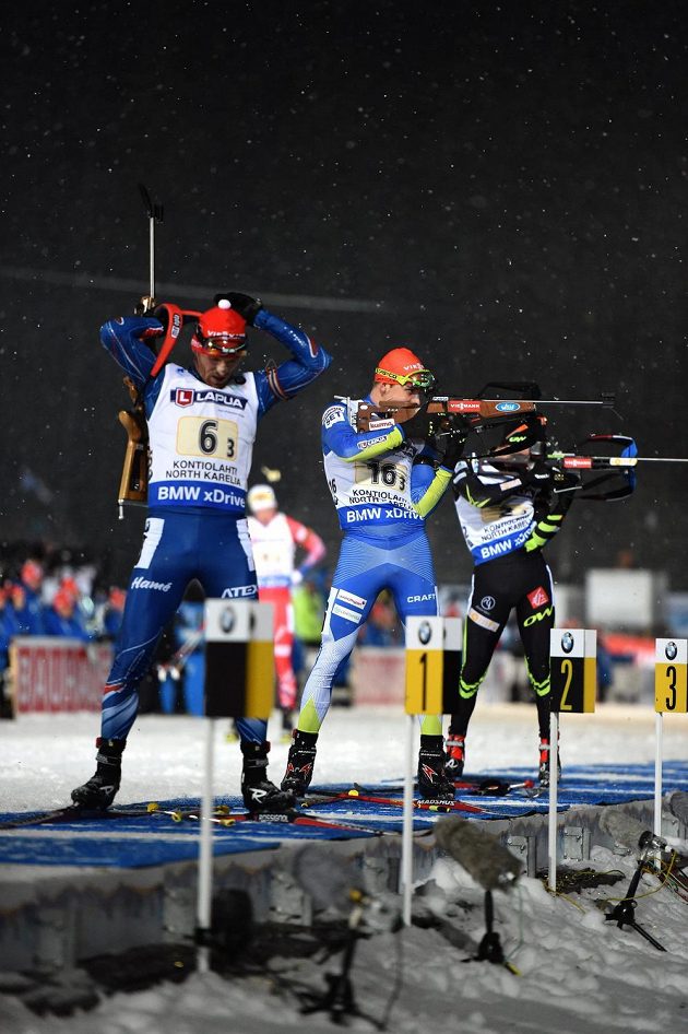 Michal Šlesingr (vlevo) opouští při závodě smíšených štafet na MS v Kontiolahti střelnici. Fin Ahti Toivanen ještě střílí.