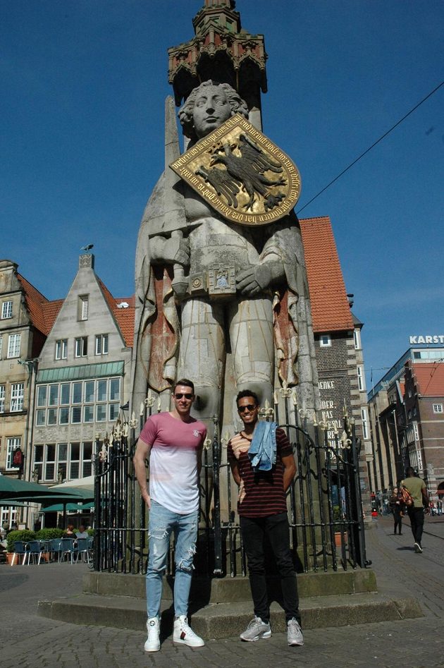 Brankář Jiří Pavlenka (vlevo) a Theodor Gebre Selassie u sochy rytíře Rolanda v centru Brém.