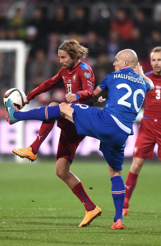Český fotbalista Jaroslav Plašil (vlevo) v souboji s Emilem Hallfredssonem z Islandu.