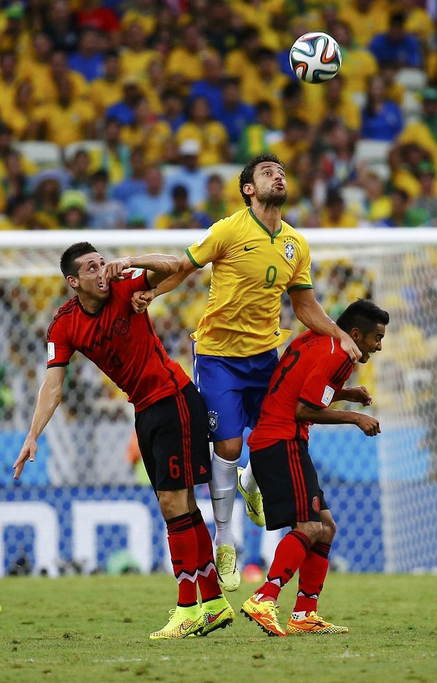 Brazilský útočník Fred v hlavičkovém souboji s Hectorem Herrerou a Josém Juanem Vazquézem (vpravo) z Mexika.