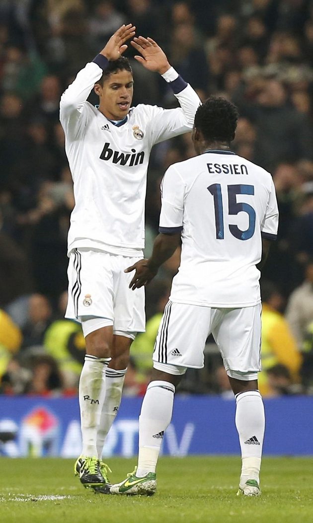 Raphael Varane z Realu Madrid (vlevo) si plácá se svým spoluhráčem Michaelem Essienem.