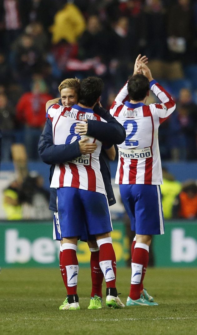 Fotbalisté Atlétika Madrid slaví vítězství nad Realem. Zleva útočník Fernando Torres, střelec prvního gólu Raúl García a stoper Diego Godín.