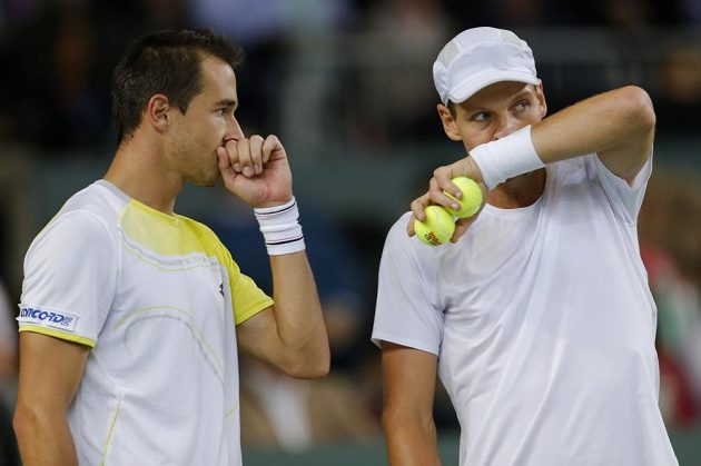 Tomáš Berdych (vpravo) a Lukáš Rosol spřádají taktické plány v zápase proti švýcarskému páru Marco Chiudinelli, Stanislas Wawrinka.