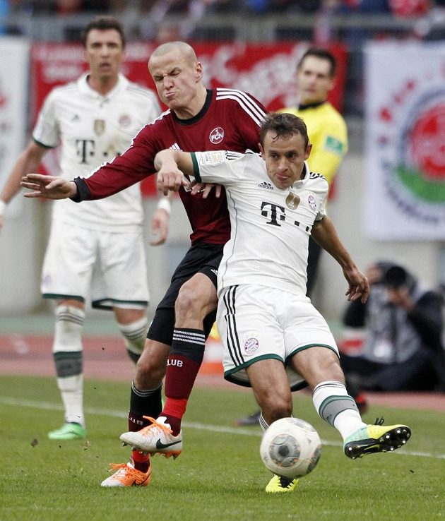 Adam Hloušek z Norimberku (v červeném) v souboji s Rafinhou z Bayernu Mnichov.