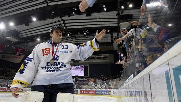 Brankář Vítkovic Jakub Štěpánek se stříbrnou medaili na krku zdraví fanoušky svého týmu.