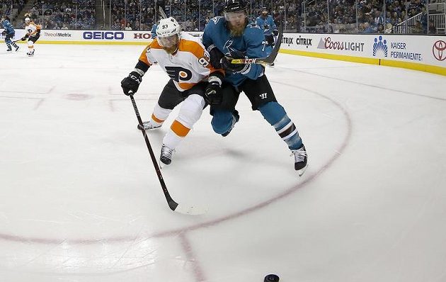 Útočník Philadelphie Flyers Jakub Voráček se žene za pukem spolu s obráncem San Jose Sharks Paulem Martinem. Voráček se v utkání NHL prosadil, přihrál na tři branky.