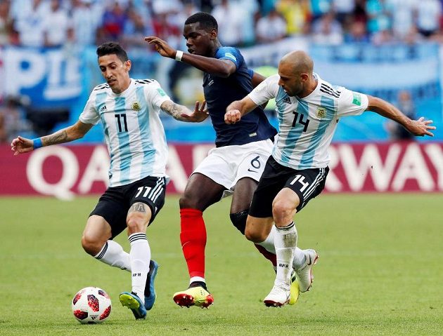 Argentinci Angel Di María (vlevo) a Javier Mascherano v souboji s Francouzem Paulem Pogbou.
