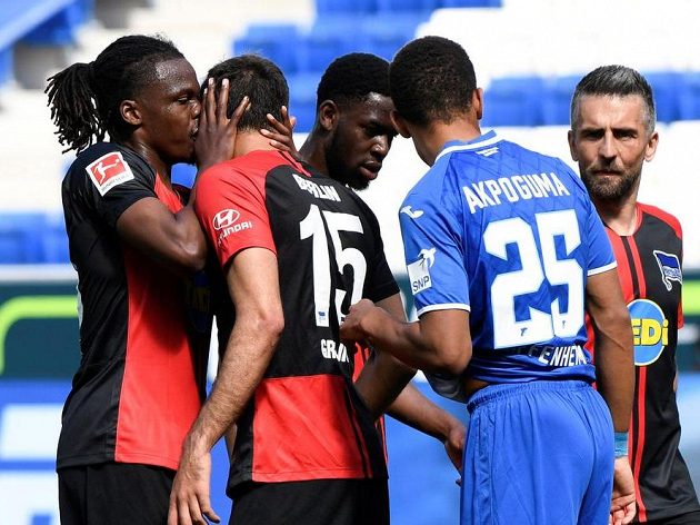 Dedryck Boyata z Herthy se neudržel a políbil Marka Grujiče, druhý zprava je hoffenheimský Kevin Akpoguma, který vlastním gólem hosty poslal do vedení.