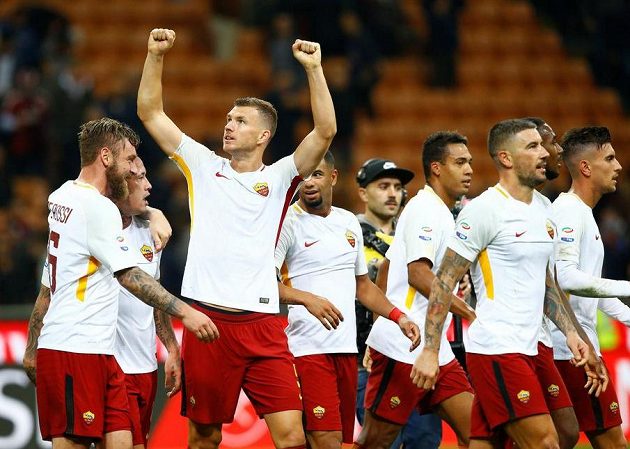 Edin Džeko (druhý zleva) a fotbalisté AS Řím se radují z výhry na hřišti AC Milán.