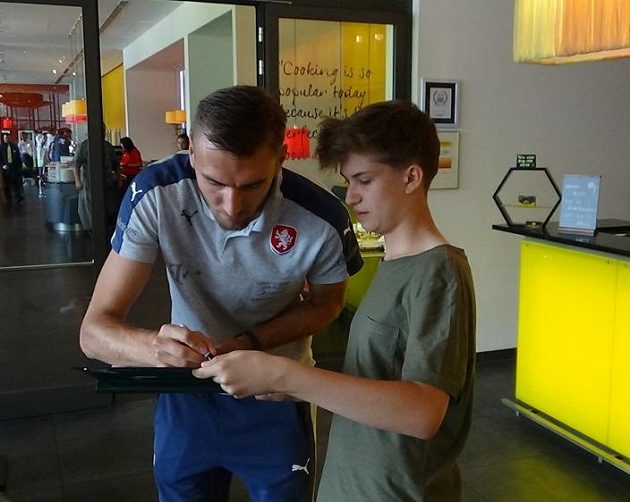 Útočník Tomáš Chorý se podepisuje jednomu z lovců autogramů po příjezdu české fotbalové reprezentace do 21 let na ME do Polska.