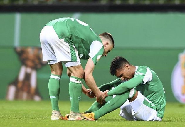 Fotbalista Brém Maximilian Eggestein utěšuje obránce Theodora Gebre Selassieho po prohraném semifinále Německého poháru.