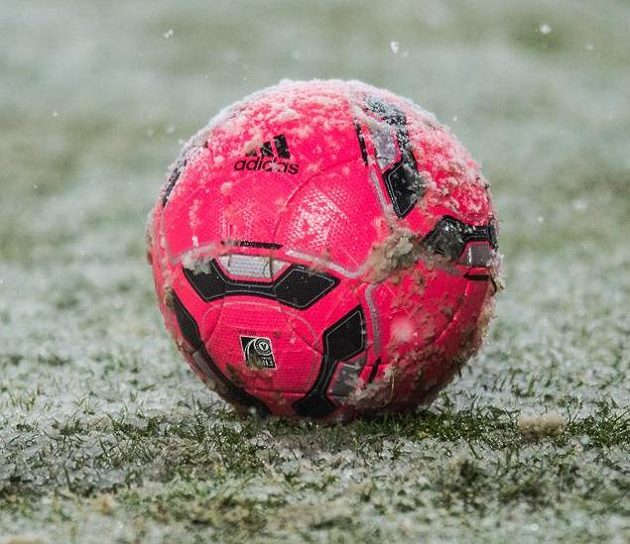 Míč na zasněžené ploše stadiónu Juliska před odloženým utkáním Dukly se Spartou.