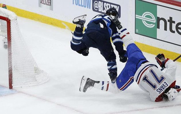 Útočník Winnipegu Jets Mark Scheifele (55) srazil Jakea Evanse (71) z Montrealu Canadiens během utkání 2. kola play off NHL.