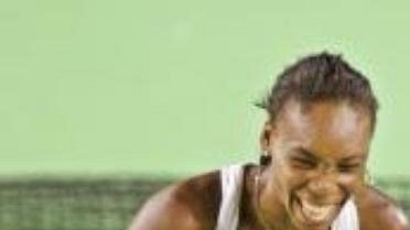 Venus (vlevo) a Serena Williamsovy pózují po finále Australian Open s trofejemi. Mladší ze sester se raduje, vyhrála čtvrtý grandslam v řadě. Venus (vlevo) a Serena Williamsovy pózují po finále Australian Open s trofejemi. Mladší ze sester se raduje, vyhrála čtvrtý grandslam v řadě.