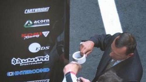 Mechanici britské stáje Bar Honda sledují policisty v civilu, kteří zabavili před víkendovou Velkou cenou Francie vozů formule 1 v garážích v Magny-Cours oba závodní vozy stáje BAR. Mechanici britské stáje Bar Honda sledují policisty v civilu, kteří zabavili před víkendovou Velkou cenou Francie vozů formule 1 v garážích v Magny-Cours oba závodní vozy stáje BAR.