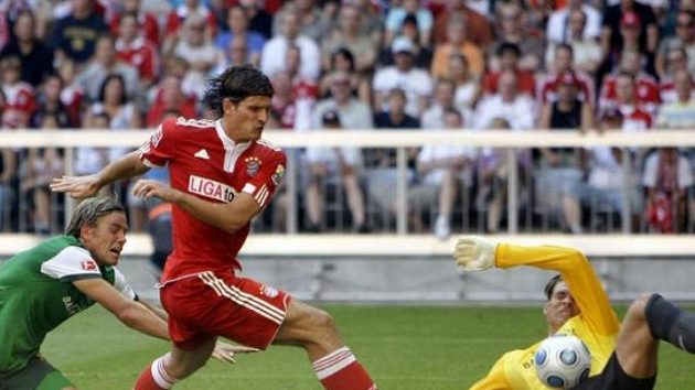Útočník Bayernu Mnichov Mario Gomez střílí gól brankáři Brém Wiesemu. Útočník Bayernu Mnichov Mario Gomez střílí gól brankáři Brém Wiesemu.