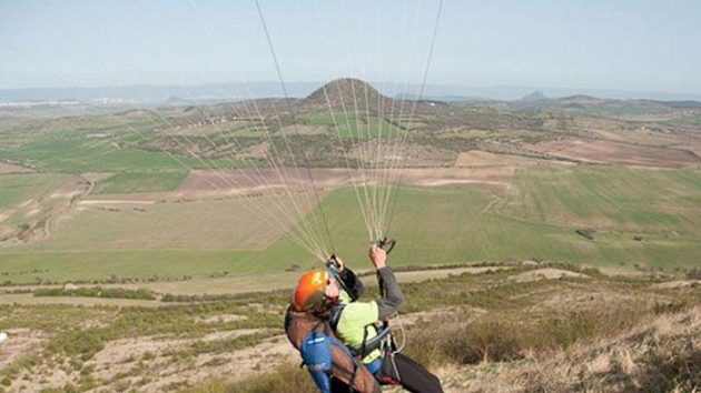 Paraglidista Jan Škrabálek krotí svůj padák na vrcholu Raná u Loun. Paraglidista Jan Škrabálek krotí svůj padák na vrcholu Raná u Loun.