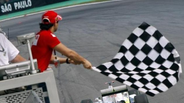 Felipe Massa z týmu Ferrari mává vlajkou při průjezdu Jensona Buttona ze stáje Brawn GP při Velké ceně Brazílie Felipe Massa z týmu Ferrari mává vlajkou při průjezdu Jensona Buttona ze stáje Brawn GP při Velké ceně Brazílie