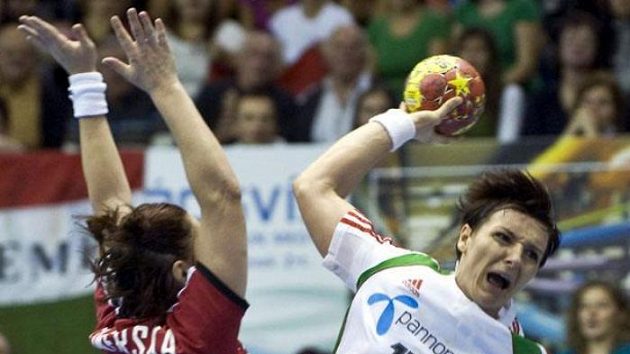 Maďarská házenkářka Timea Tóthová střílí přes bránící českou reprezentantku. Maďarská házenkářka Timea Tóthová střílí přes bránící českou reprezentantku.