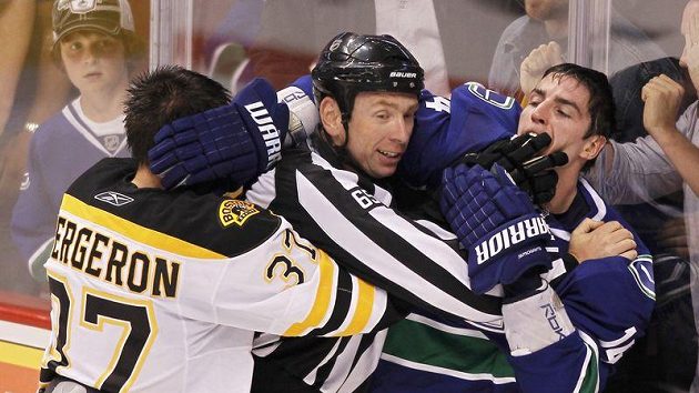 Centr Bostonu Bruins Patrice Bergeron se přetlačuje s Alexem Burrowsem z Vancouveru. Centr Bostonu Bruins Patrice Bergeron se přetlačuje s Alexem Burrowsem z Vancouveru.