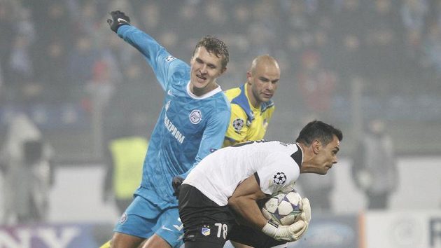 Alexandr Bucharov z Petrohradu dotírá na brankáře APOELu Nikosia Paula Jorga v utkání Ligy mistrů. Alexandr Bucharov z Petrohradu dotírá na brankáře APOELu Nikosia Paula Jorga v utkání Ligy mistrů.