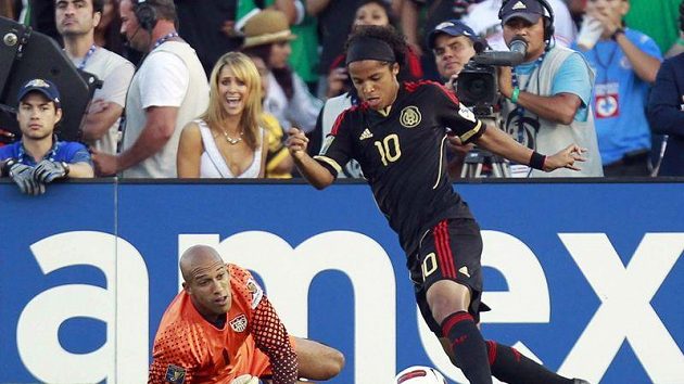 Mexický útočník Giovani dos Santos obchází gólmana Spojených států americkým Tima Howarda a vzápětí přidá výstavní gól. Mexický útočník Giovani dos Santos obchází gólmana Spojených států americkým Tima Howarda a vzápětí přidá výstavní gól.