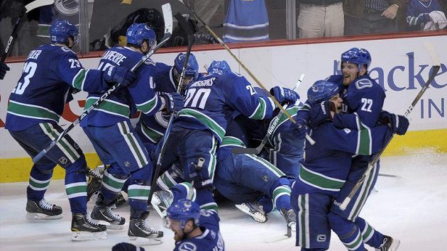 Hokejisté Vancouveru zalehávají Alexe Burrowse, který právě rozhodl o postupu Canucks a vyřazení Chicaga v 1. kole Stanley Cupu. Hokejisté Vancouveru zalehávají Alexe Burrowse, který právě rozhodl o postupu Canucks a vyřazení Chicaga v 1. kole Stanley Cupu.