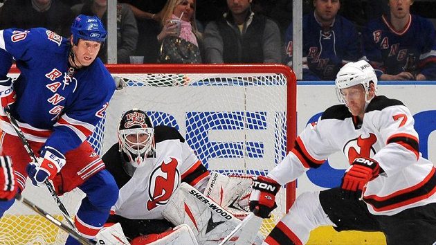 Václav Prospal (20) z New Yorku Rangers čeká na dorážku před brankářem New Jersey Devils Martinem Brodeurem. střelu se snaží zblokovat Henrik Tallinder (7). Václav Prospal (20) z New Yorku Rangers čeká na dorážku před brankářem New Jersey Devils Martinem Brodeurem. střelu se snaží zblokovat Henrik Tallinder (7).