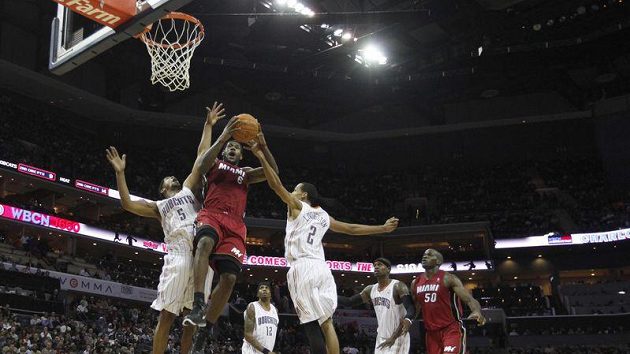 LeBron James z Miami (uprostřed) se prosazuje mezi dvojicí hráčů Charlotte. LeBron James z Miami (uprostřed) se prosazuje mezi dvojicí hráčů Charlotte.