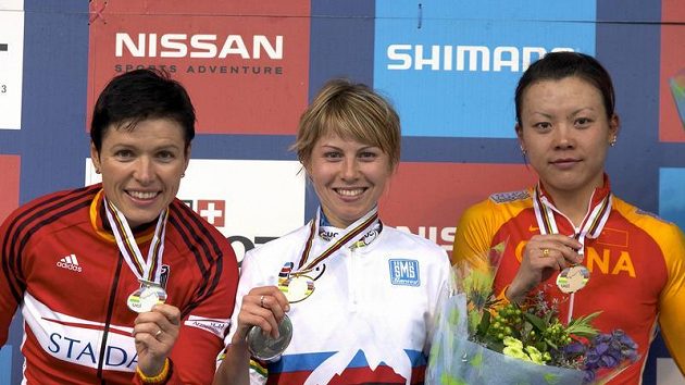 Ruská cyklistka Irina Kalenťjevová (uprostřed) ukazuje svou zlatou medaili ze závodu horských kol na MS ve skotském Fort Williamu v cross country. Vlevo je stříbrná Němka Sabine Spitzová, vpravo pak Ťing Ťing-wang z Číny. Ruská cyklistka Irina Kalenťjevová (uprostřed) ukazuje svou zlatou medaili ze závodu horských kol na MS ve skotském Fort Williamu v cross country. Vlevo je stříbrná Němka Sabine Spitzová, vpravo pak Ťing Ťing-wang z Číny.