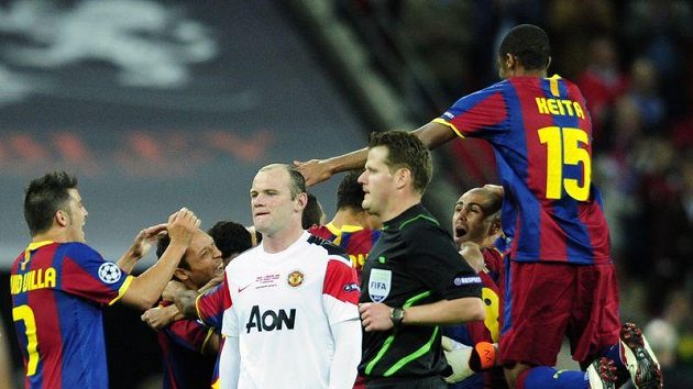 Zklamaný Wayne Rooney v kontrastu s radujícími se hráči Barcelony po konci finálového zápasu Ligy mistrů. Zklamaný Wayne Rooney v kontrastu s radujícími se hráči Barcelony po konci finálového zápasu Ligy mistrů.