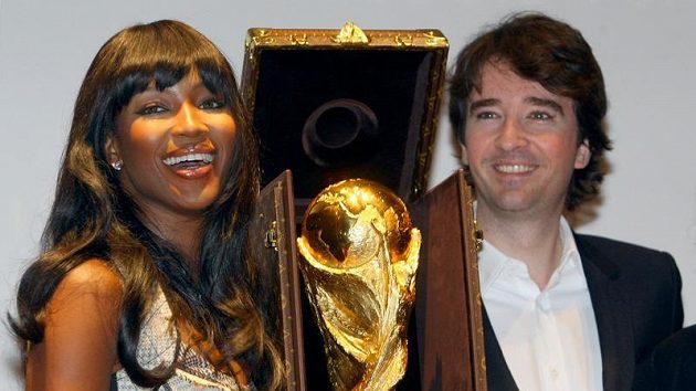 Pohár pro fotbalové mistry světa v luxusním pouzdru od Louis Vuitton mezi ředitelem komunikace firmy Antoine Arnaultem a topmodelkou Naomi Campbell Pohár pro fotbalové mistry světa v luxusním pouzdru od Louis Vuitton mezi ředitelem komunikace firmy Antoine Arnaultem a topmodelkou Naomi Campbell