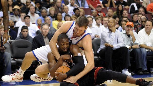 V nebasketové pozici zápolí o míč Spencer Hawes z Filadelfie (v bílém) s Dwyanem Wadem z Miami Heats. V nebasketové pozici zápolí o míč Spencer Hawes z Filadelfie (v bílém) s Dwyanem Wadem z Miami Heats.