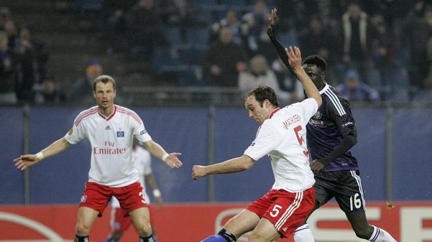 David Rozehnal v dresu Hamburku (v pozadí) sleduje svého spoluhráče Jorise Mathijsena, jak střílí v utkání proti Anderlechtu. David Rozehnal v dresu Hamburku (v pozadí) sleduje svého spoluhráče Jorise Mathijsena, jak střílí v utkání proti Anderlechtu.