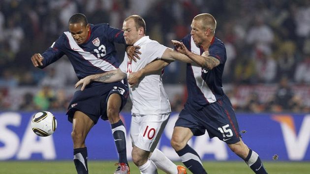 Anglický útočník Wayne Rooney (uprostřed) se snaží prosadit mezi Američany Jayem DeMeritem a Ricardem Clarkem. Anglický útočník Wayne Rooney (uprostřed) se snaží prosadit mezi Američany Jayem DeMeritem a Ricardem Clarkem.