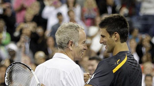 Tenisová legenda John McEnroe (vlevo) a současný tenista Novak Djokovič se zdraví nad sítí. Tenisová legenda John McEnroe (vlevo) a současný tenista Novak Djokovič se zdraví nad sítí.