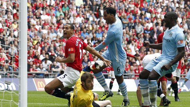Joleon Lescott (třetí zleva) z Manchestru City překonává gólmana Manchesteru United De Geu. Joleon Lescott (třetí zleva) z Manchestru City překonává gólmana Manchesteru United De Geu.