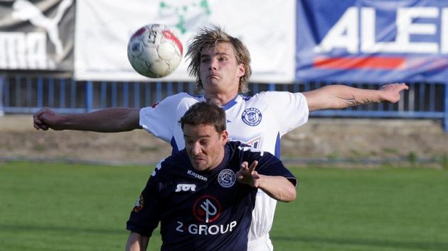 Kladenský Vít Beneš skáče po míči za Petrem Švancarou ze Slovácka Kladenský Vít Beneš skáče po míči za Petrem Švancarou ze Slovácka