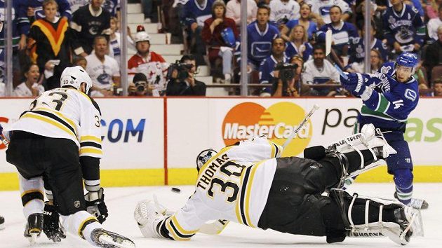 Brankář Bostonu Tim Thomas padá do střely Burrowse z Vancouveru ve finále NHL Brankář Bostonu Tim Thomas padá do střely Burrowse z Vancouveru ve finále NHL