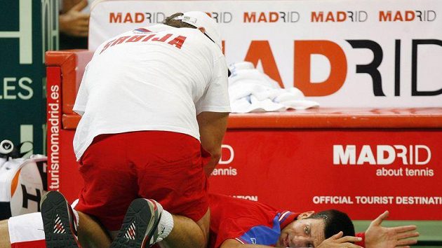 Zraněný srbský tenista Novak Djokovič v péči fyzioterapeuta. Zraněný srbský tenista Novak Djokovič v péči fyzioterapeuta.