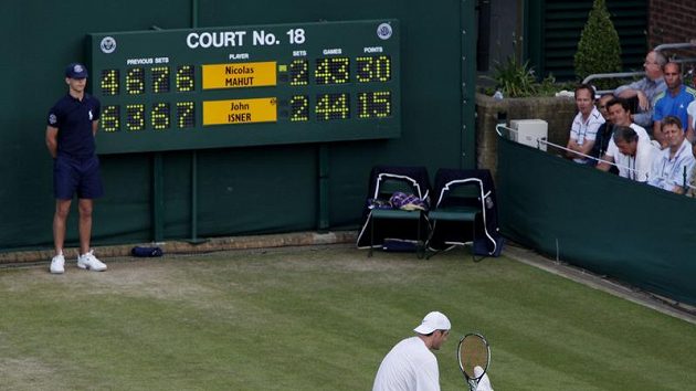 John Isner sedí na dvorci ve Wimbledonu v pátém setu v utkání proti Nicolasi Mahutovi z Francie. John Isner sedí na dvorci ve Wimbledonu v pátém setu v utkání proti Nicolasi Mahutovi z Francie.