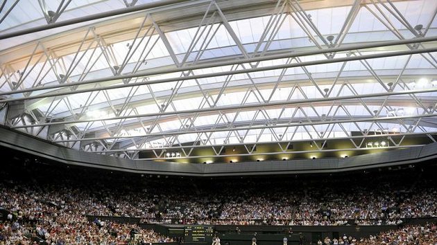 Britský tenista Andy Murray servíruje pod zataženou střehou centrálního kurtu ve Wimbledonu proti Stanislasu Wawrinkovi ze Švýcarska. Britský tenista Andy Murray servíruje pod zataženou střehou centrálního kurtu ve Wimbledonu proti Stanislasu Wawrinkovi ze Švýcarska.