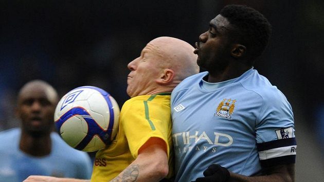 Obránce Manchesteru City Kolo Touré brání Lee Hughese z Notts County. Obránce Manchesteru City Kolo Touré brání Lee Hughese z Notts County.