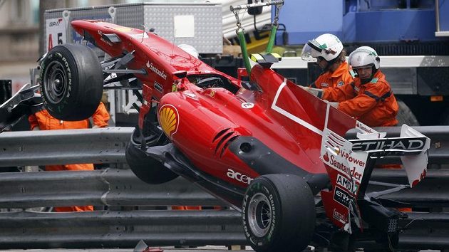 Rozbité Alonsovo farrari odtahují záchranáři mimo trať. Rozbité Alonsovo farrari odtahují záchranáři mimo trať.