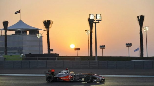 Jezdec McLarenu Lewis Hamilton na trati při západu slunce Jezdec McLarenu Lewis Hamilton na trati při západu slunce