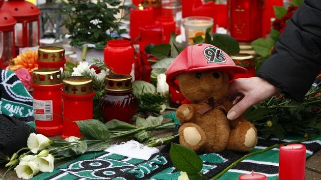 Květiny, šály Hannoveru a svíčky pokládají fanoušci na místo klubového sídla Hannoveru, aby uctili památku Roberta Enkeho. Květiny, šály Hannoveru a svíčky pokládají fanoušci na místo klubového sídla Hannoveru, aby uctili památku Roberta Enkeho.